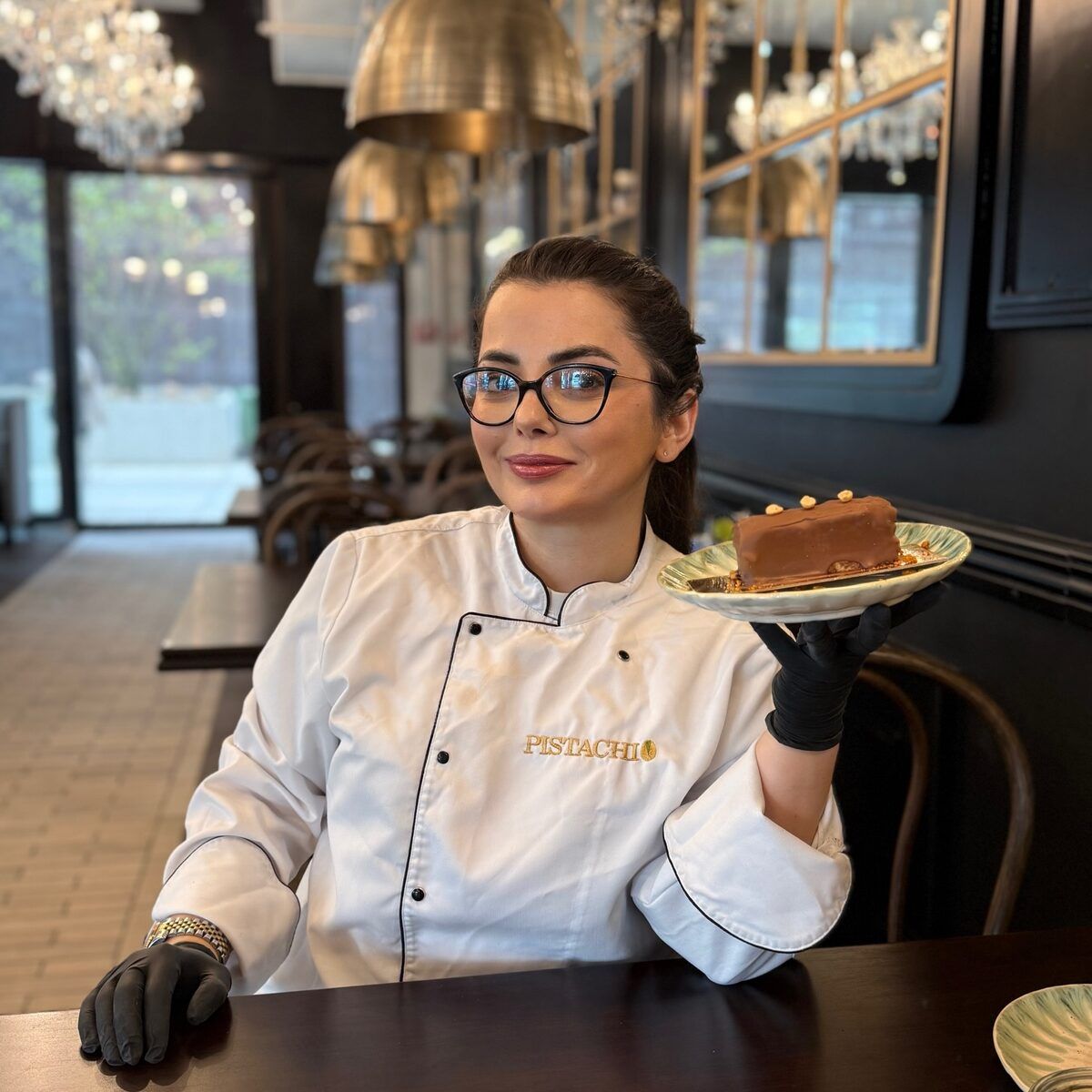 Konditorin von Pistachio präsentiert ein Dessert im Café