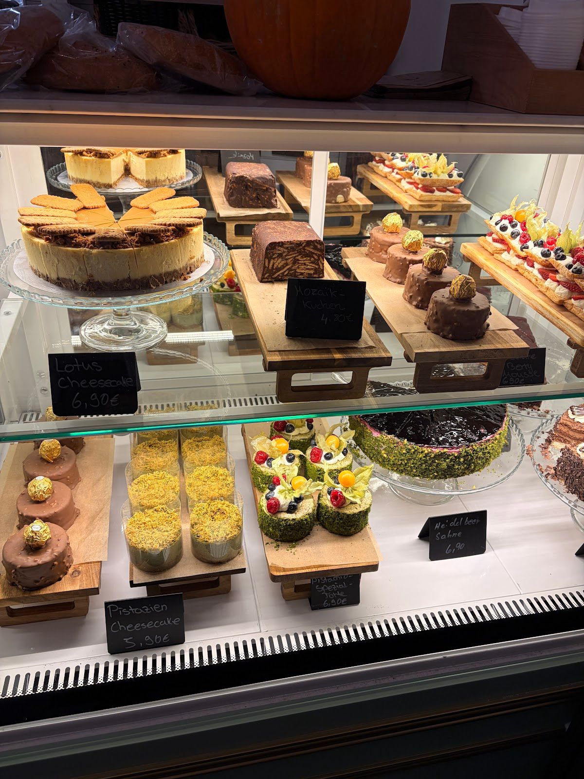 Vitrine mit Pistazien-Cheesecake, Lotus-Cheesecake und Mosaik-Kuchen